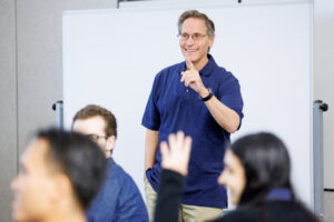 Smiling man pointing while teaching